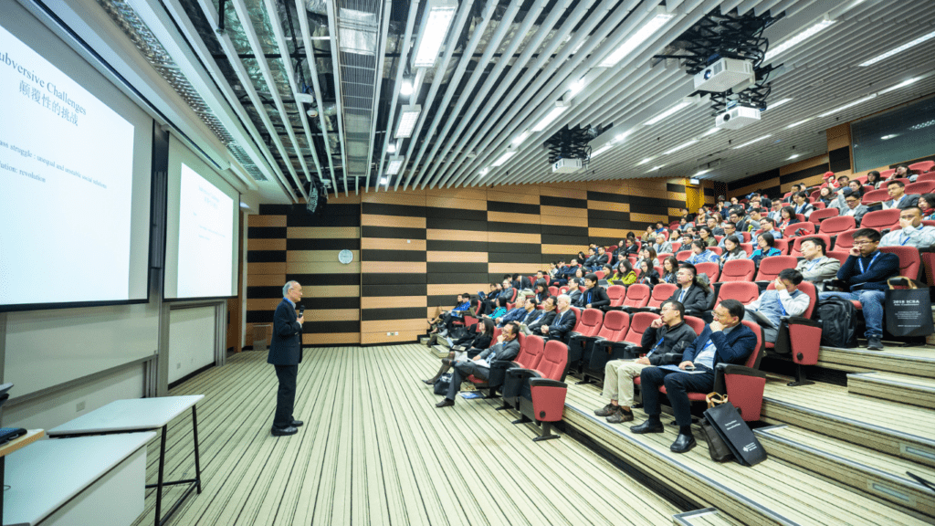 A person giving a presentation in front of a large audience