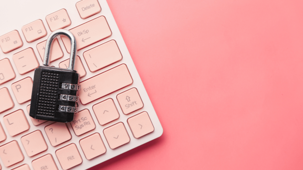 a red padlock sits on top of a laptop keyboard