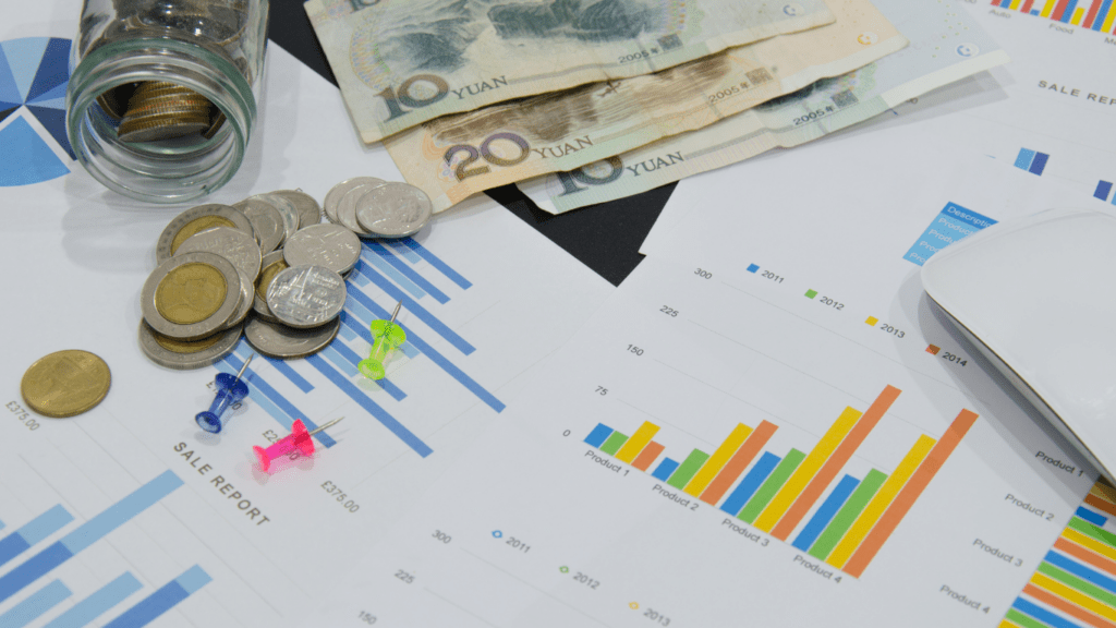 money, coins and graphs on a desk